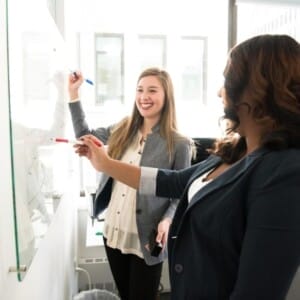 two women in front of dry erase board 1181533