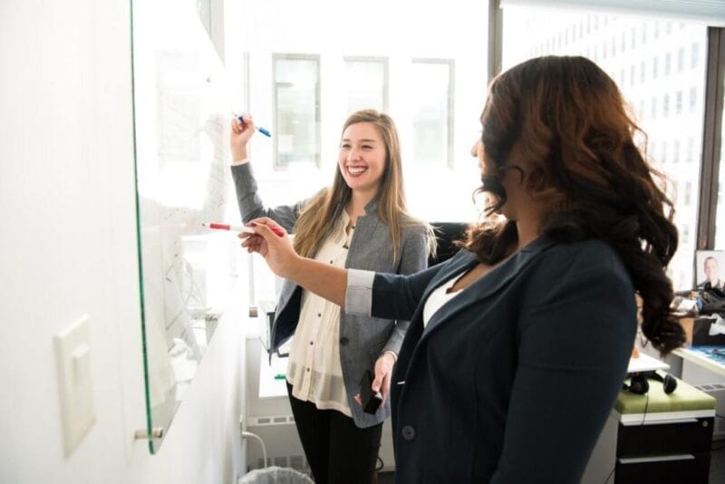 two women in front of dry erase board 1181533